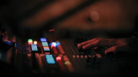 Hands on a soundboard at a live music vene 