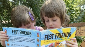  Two young children sitting outside reading a book titled "Fest Friends" 