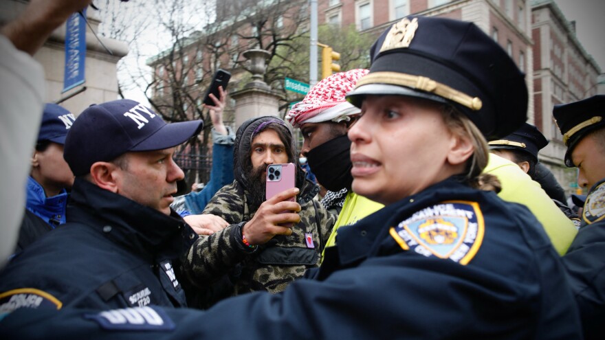 NYPD officers detain a person as pro-Palestinian protesters gather outside of Columbia University in New York City on Thursday. Officers cleared out a pro-Palestinian campus demonstration, a day after university officials testified about anti-Semitism before Congress.